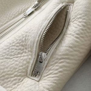 Close-up of a zipper on a white Annabelle Aviator Sheepskin Jacket showcasing detailed texture and premium craftsmanship.