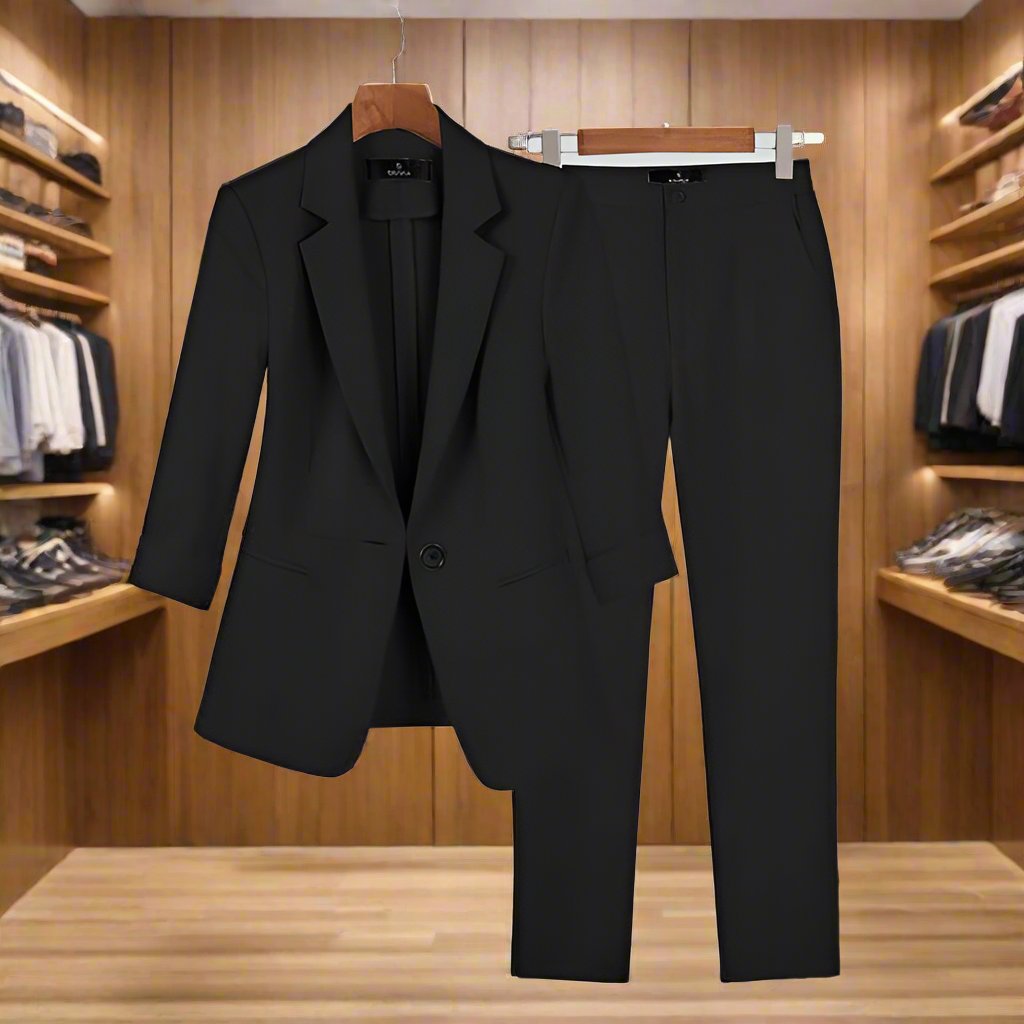 Black Melanie Premium Suit for women with tailored jacket and pants, displayed on wooden hangers against a light background.